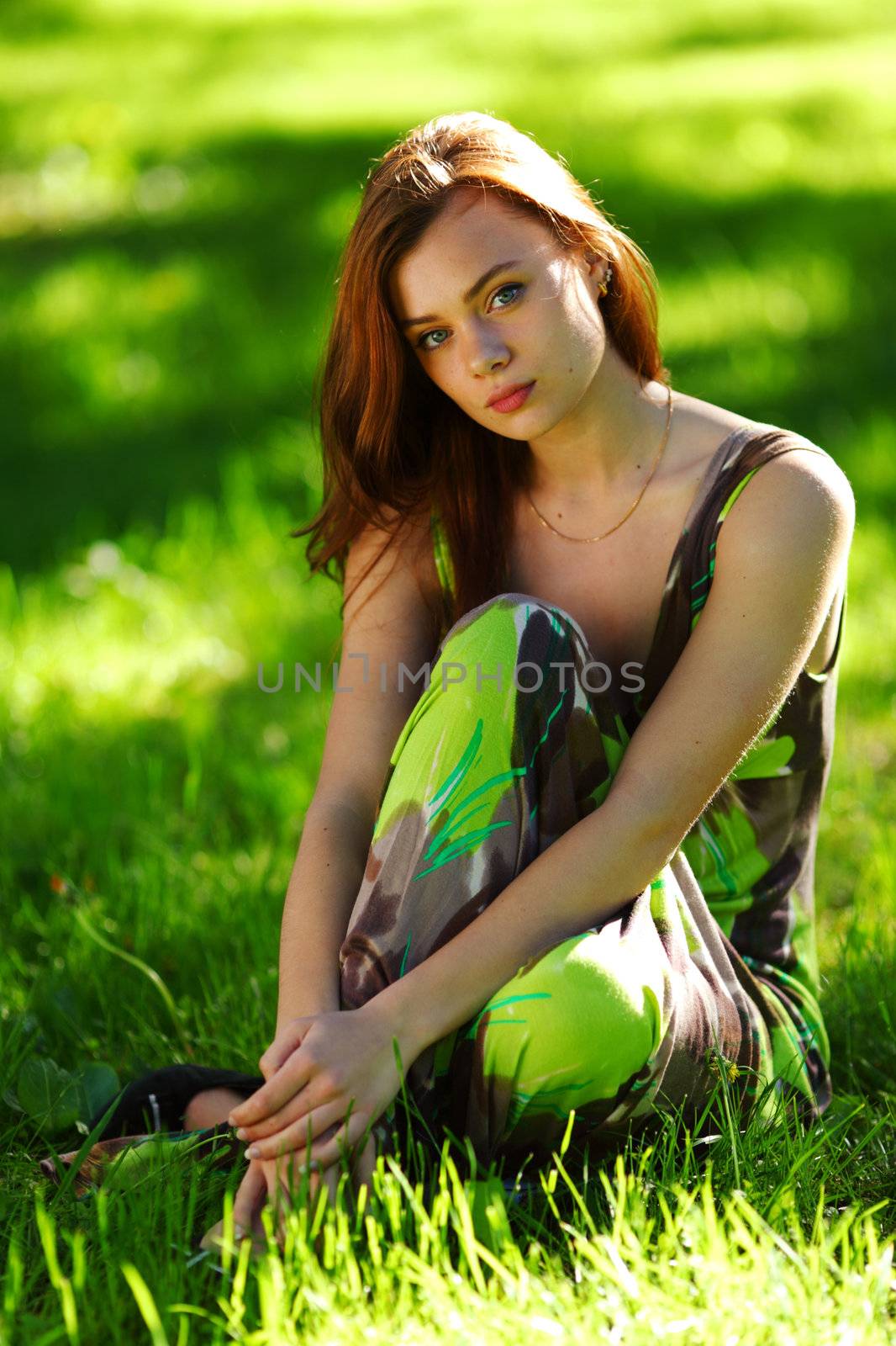 brunette sitting on green grass