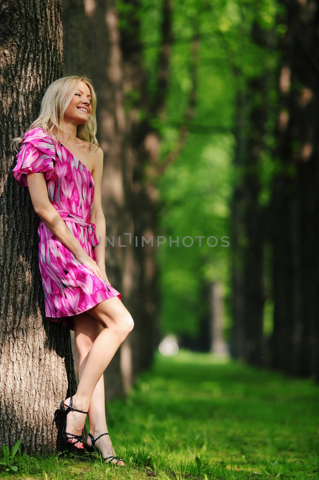 Woman stay on a shady park alley