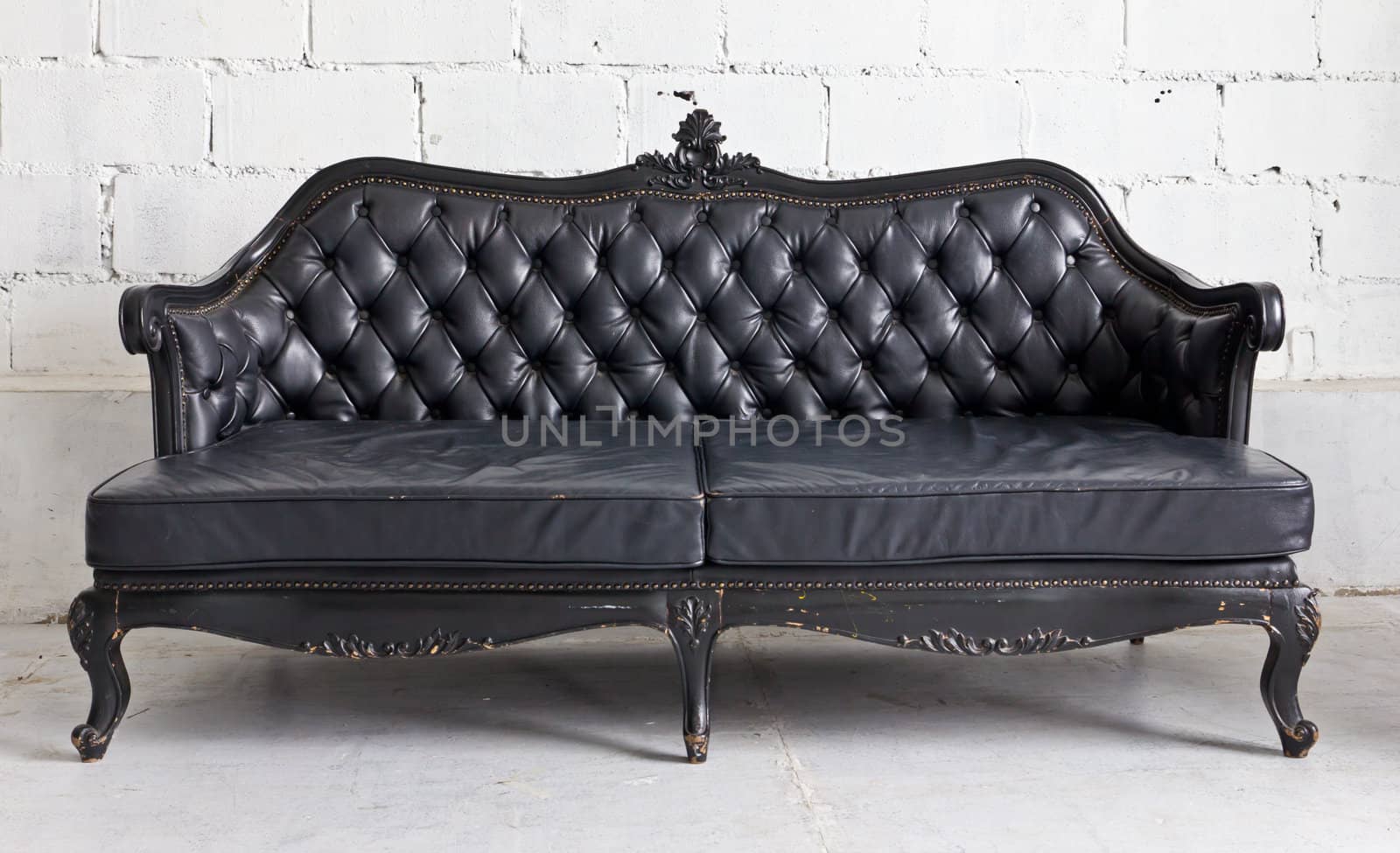 black vintage armchair in white room by tungphoto