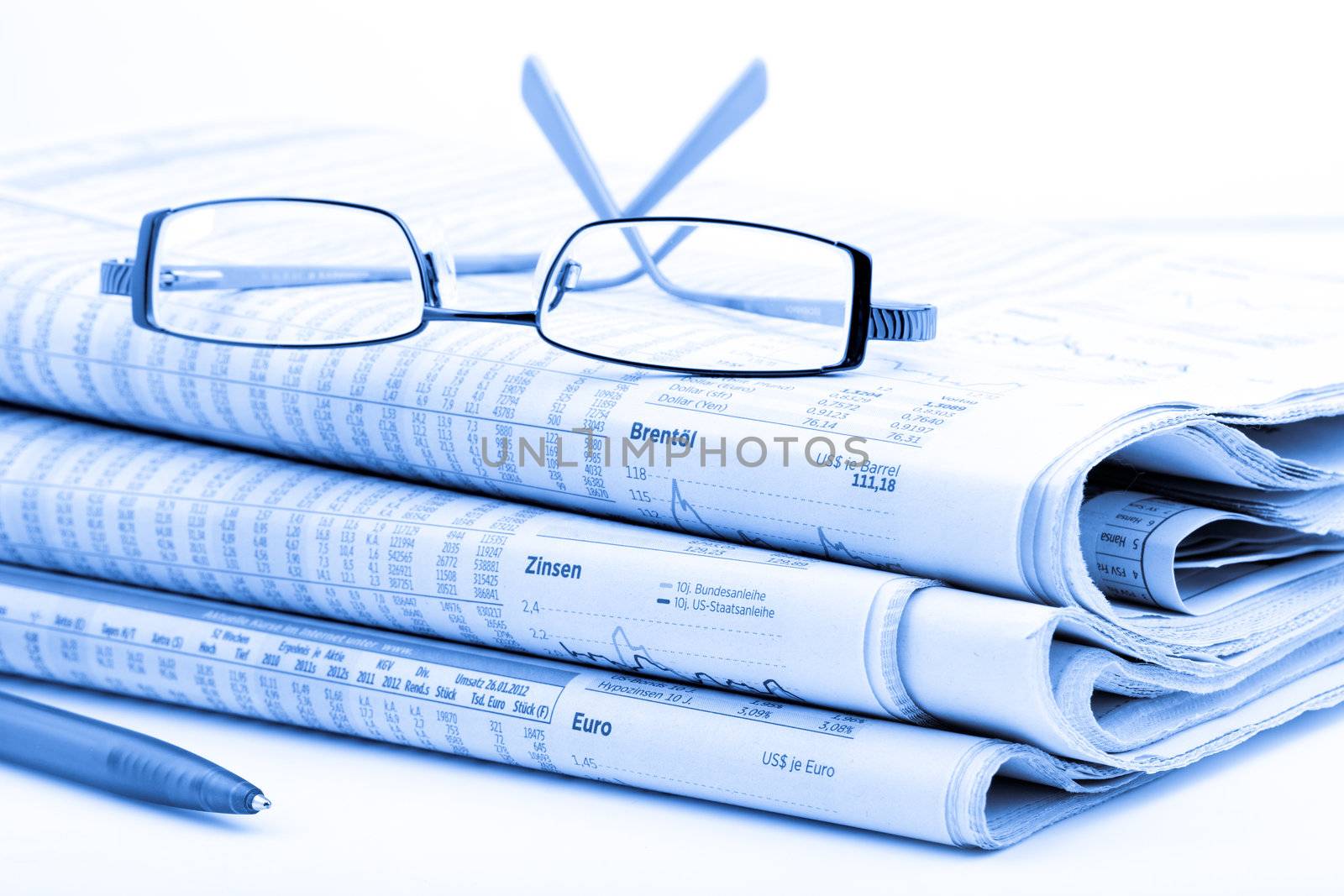 Stack of newspapers and glasses blue toned  by motorolka