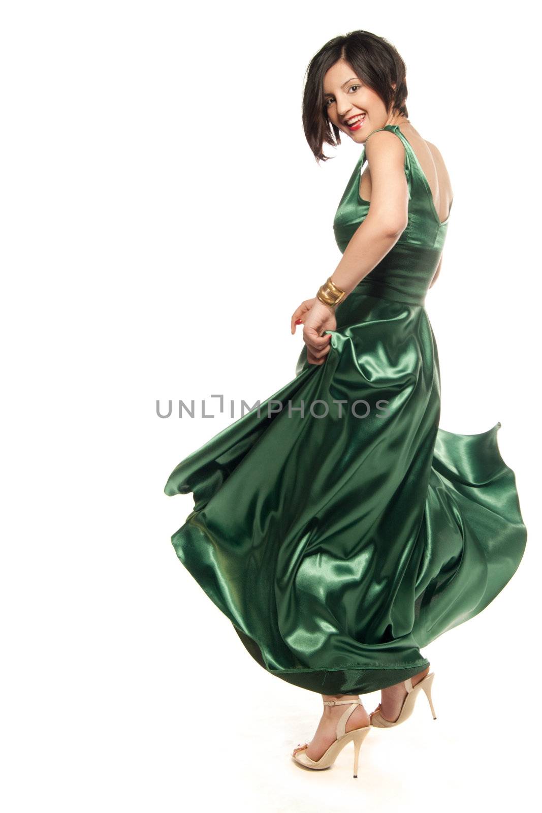 Young woman spinning in a green dress isolated on white