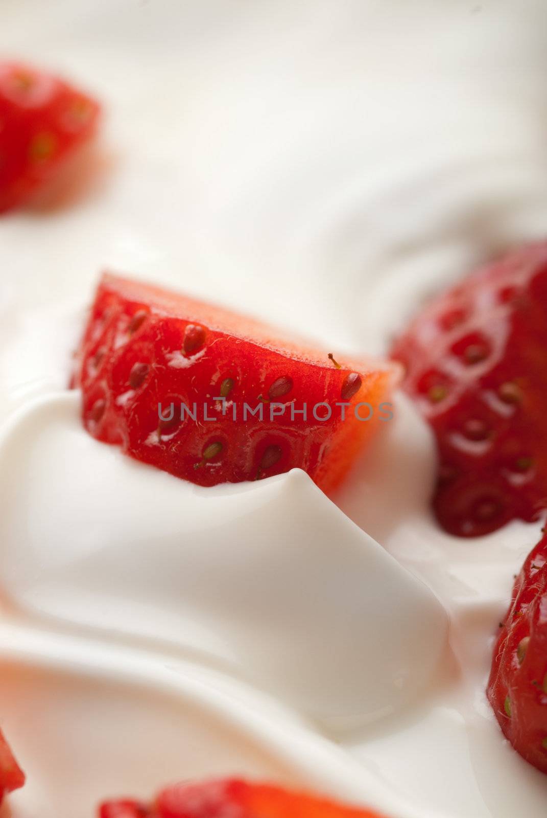 Pieces of strawberries in white whipped vanilla cream