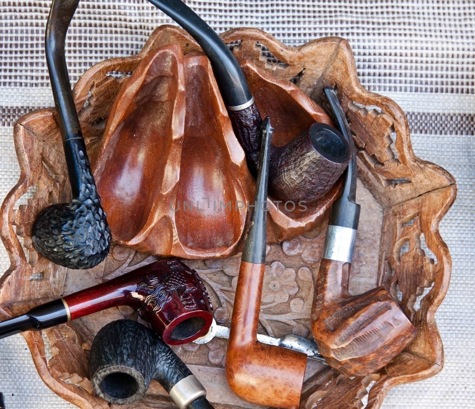 several different smoking pipes - made of wood