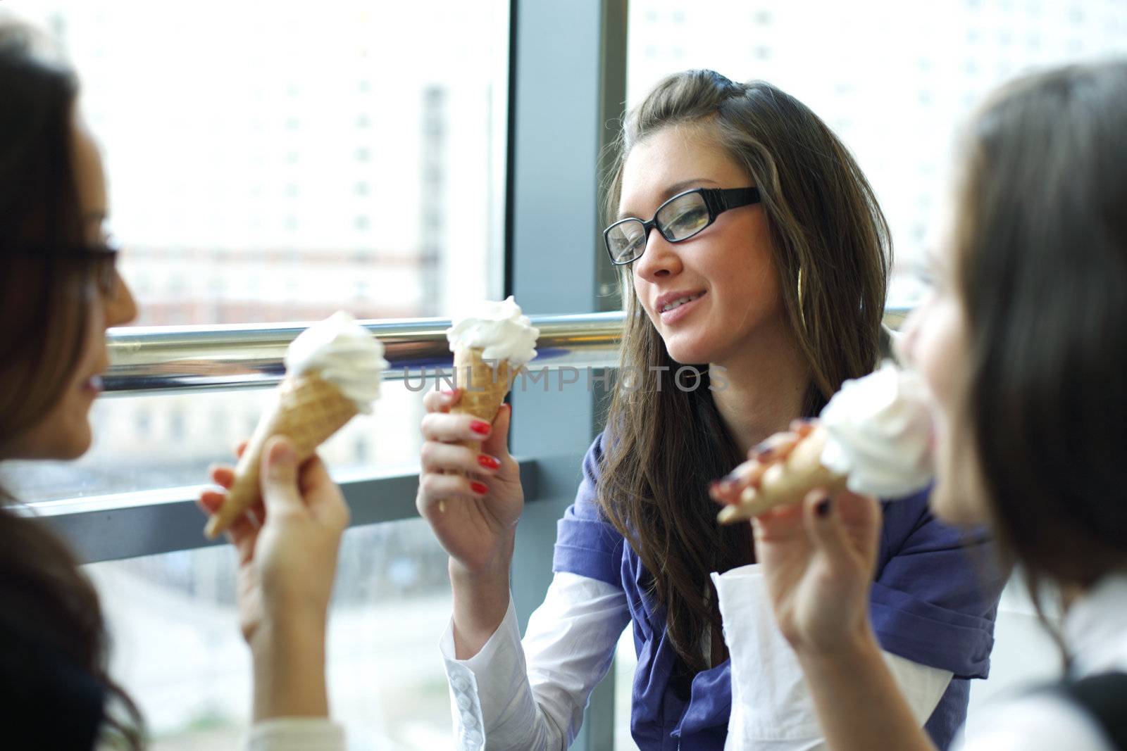 women on foreground licking ice cream 