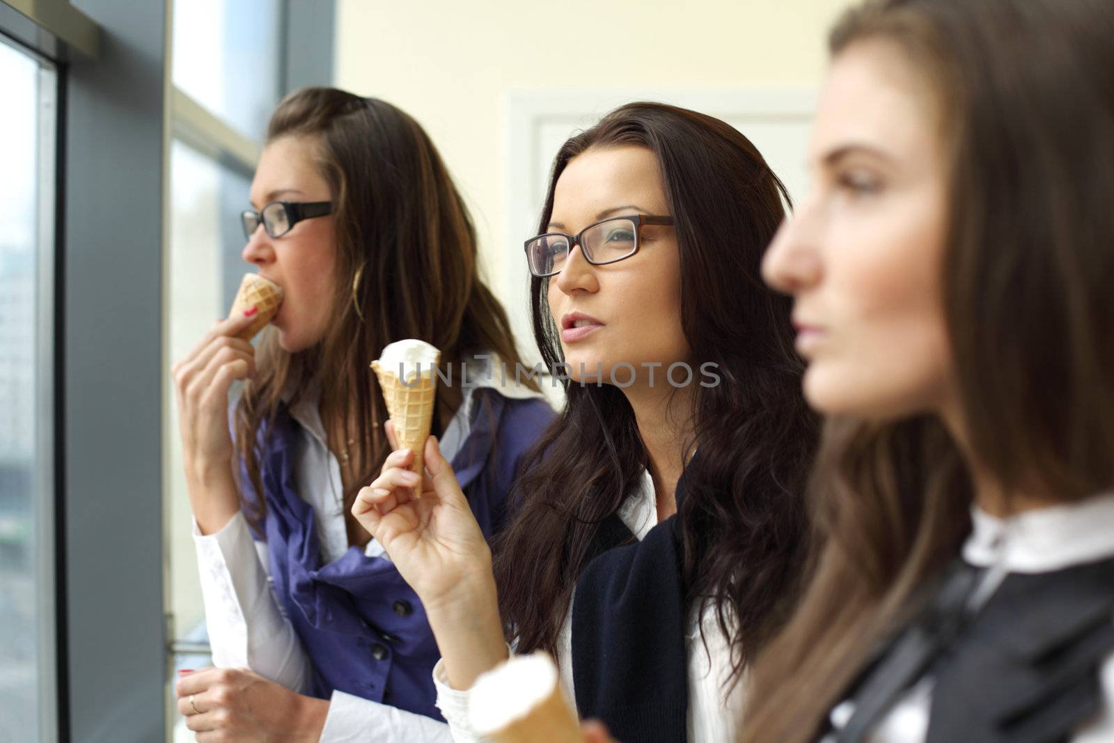 happy smiling women on foreground licking ice cream 