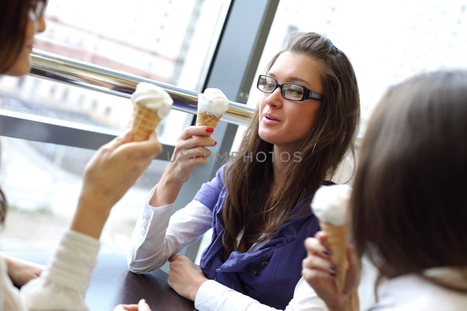 women on foreground licking ice cream 