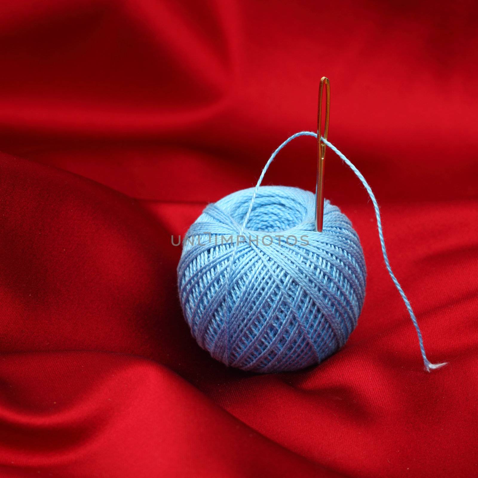 thread on red silk isolated close up