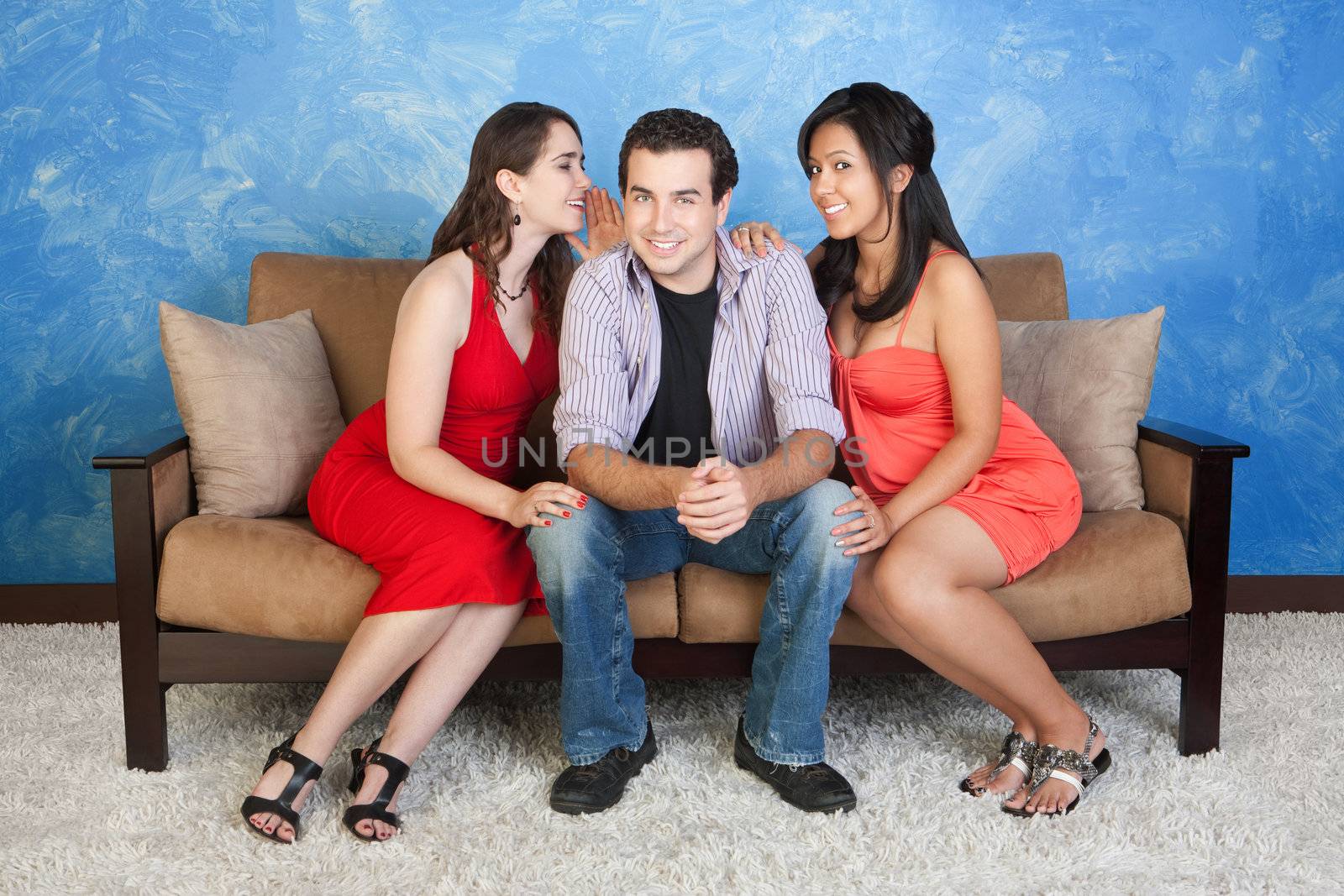 Two pretty women whisper and flirt with handsome man
