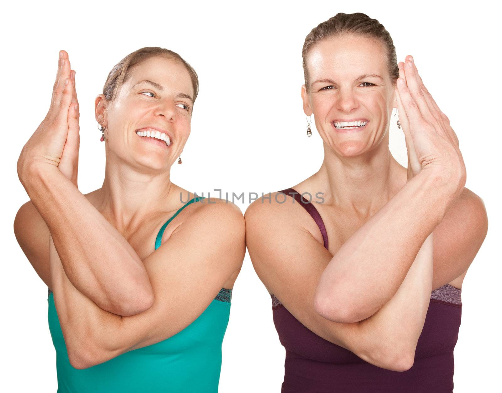 Two smiling women in Namaskar pose with twisted hands