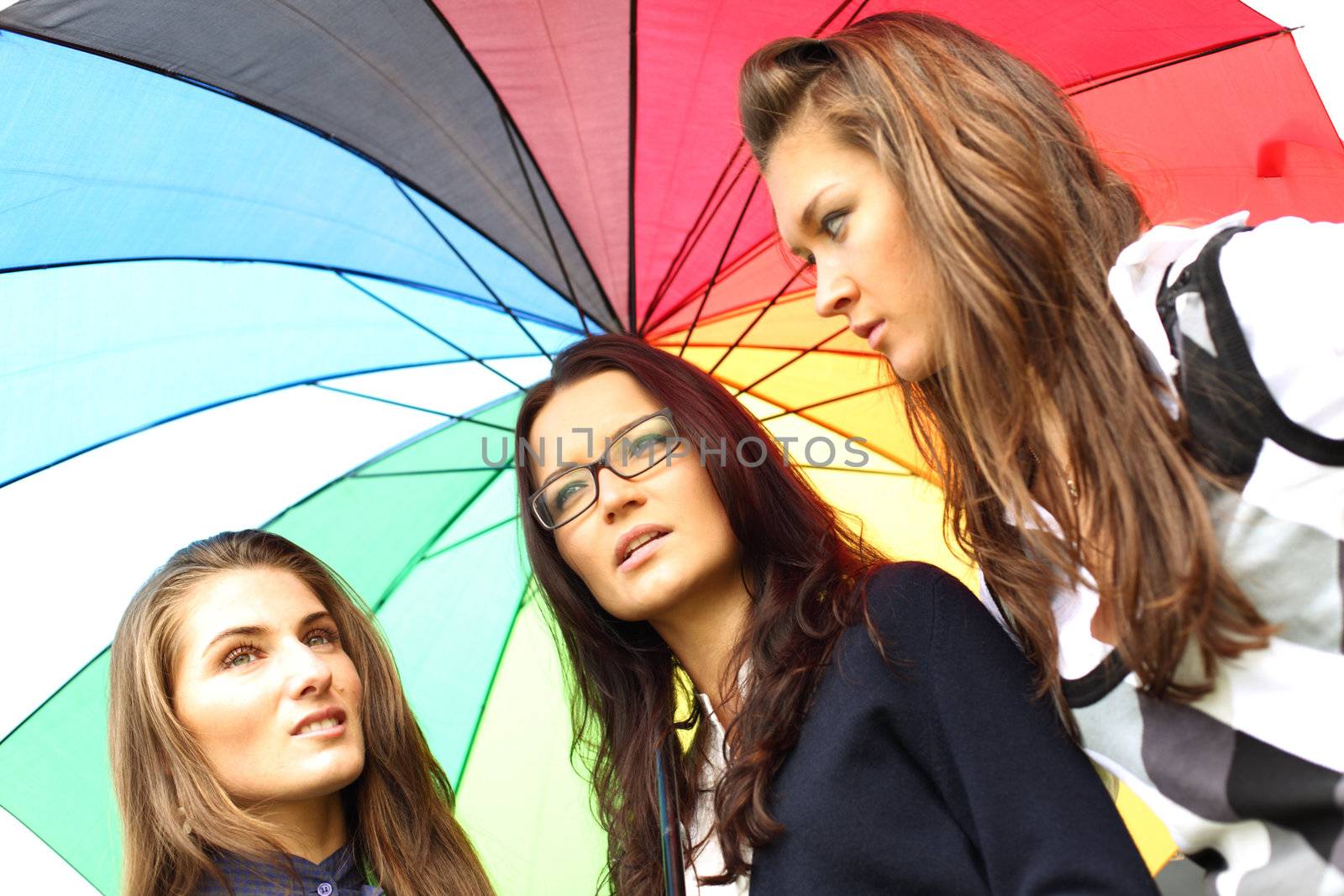 girlfriends stay under colourful umbrella 