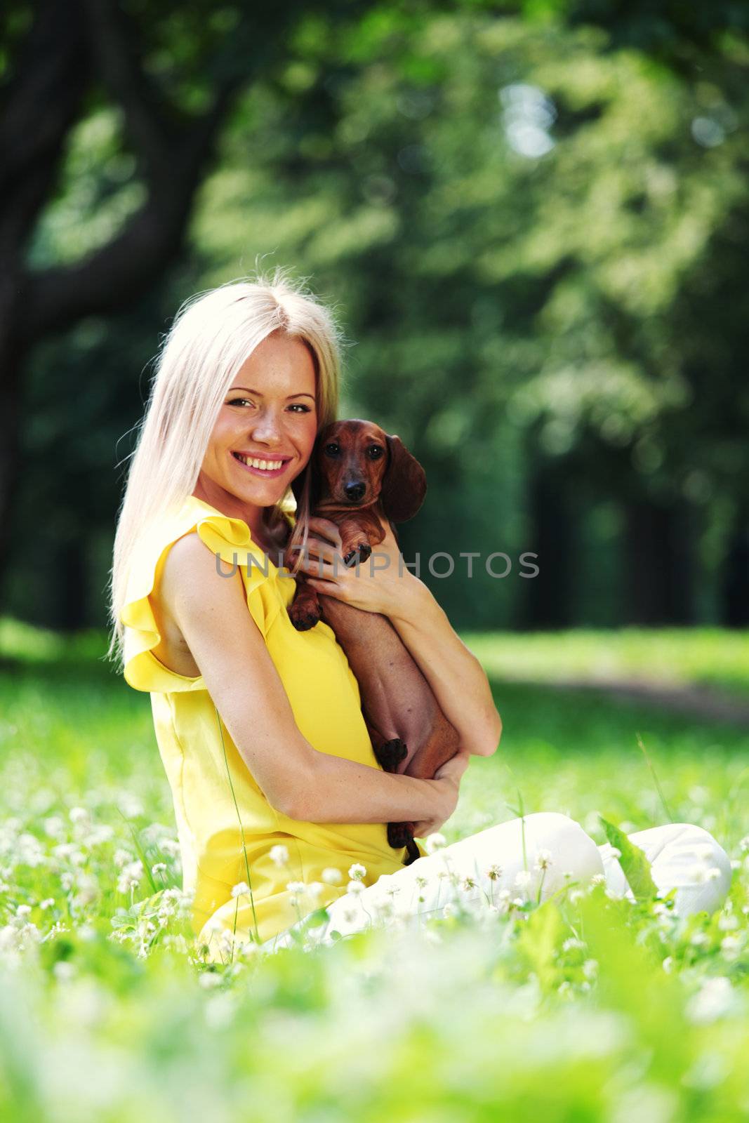 woman dachshund in her arms on grass