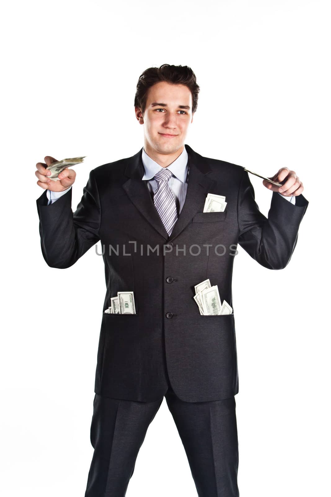 Portrait of a young businessman in a dark suit surrounded by flying dollar bills