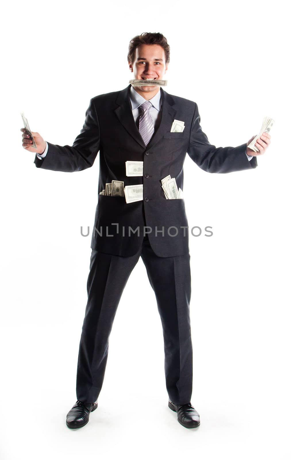 Portrait of a young businessman in a dark suit surrounded by flying dollar bills