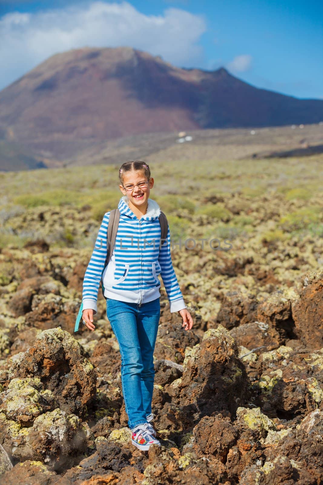 Cute young girl with backpack have trip in the mountains. Verticl