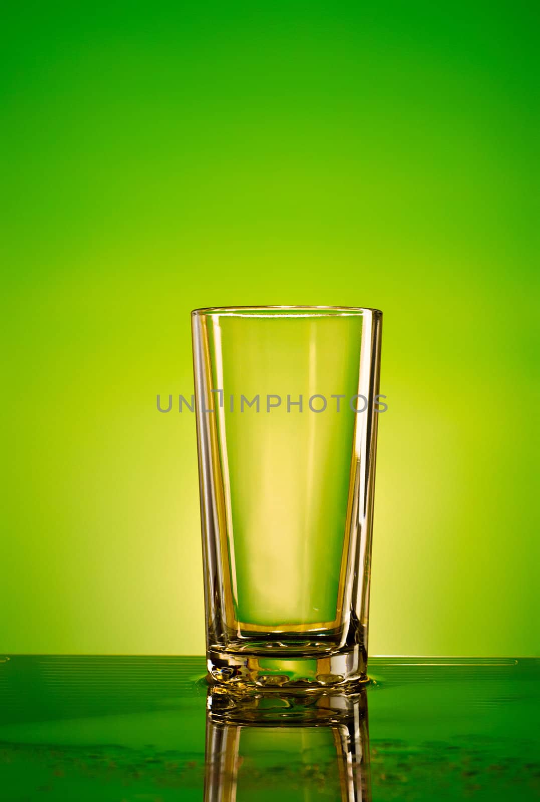 empty glass on green and yellow background