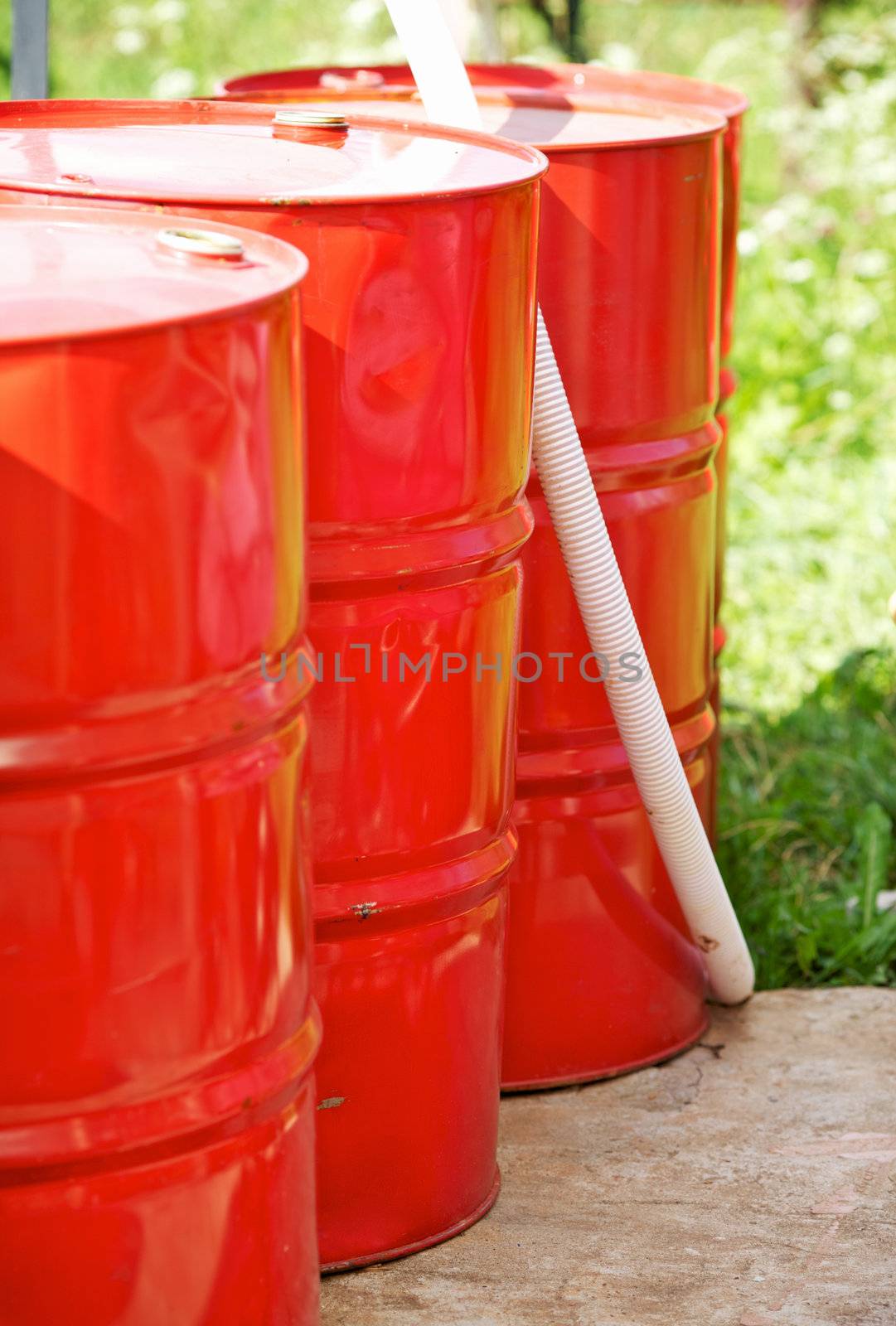 three old red metal barrels in yard