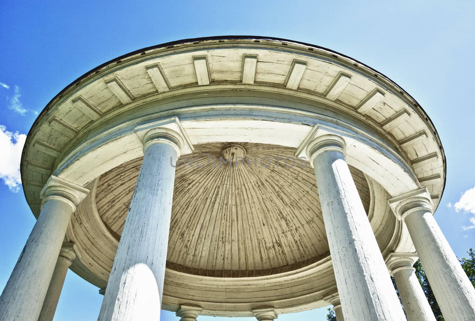 classical circular temple in garden, blue sky background