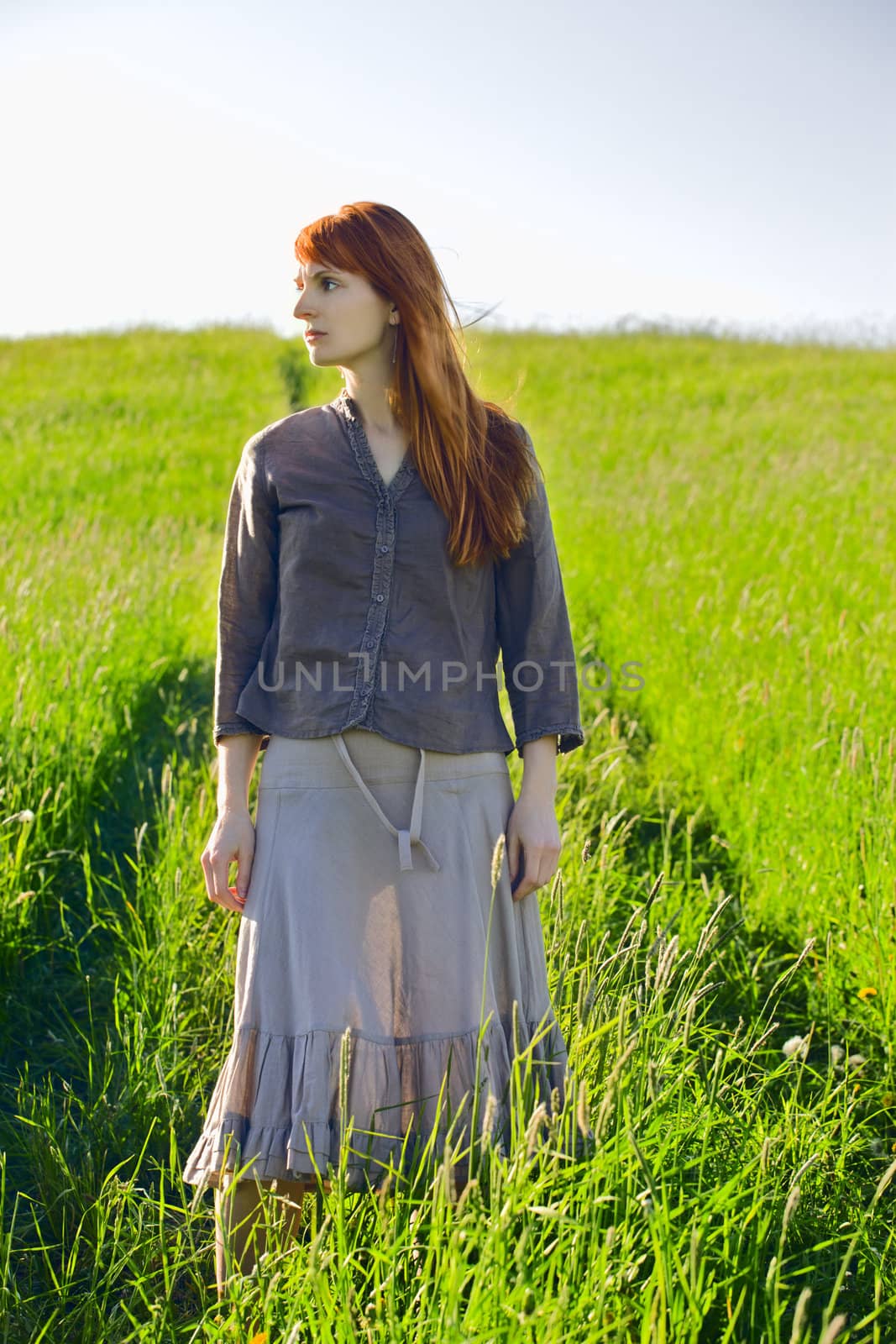 sad woman standing in field at summer day