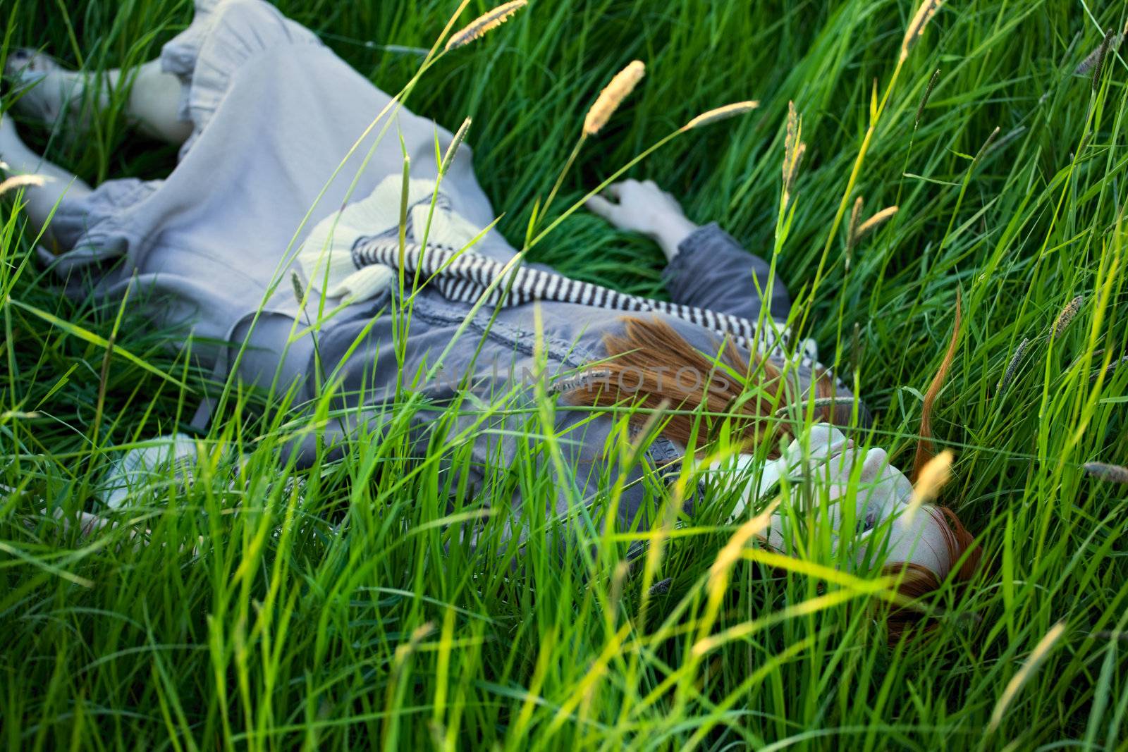 dead woman laying in high grass at summer day