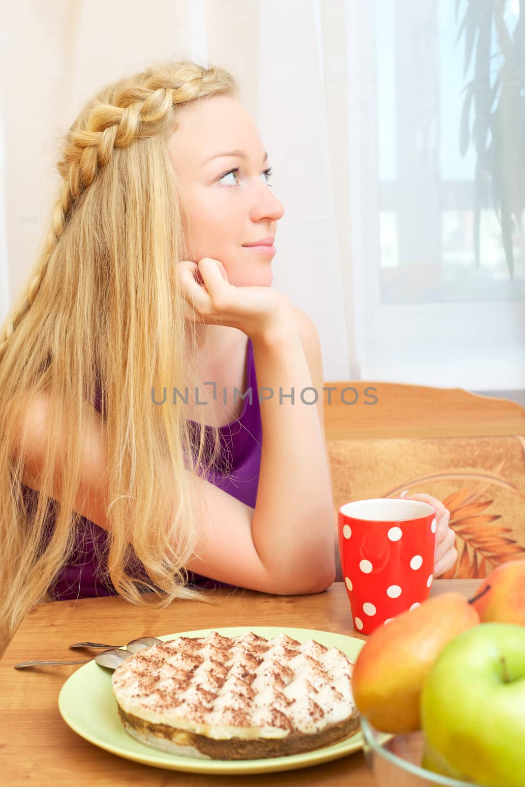 young woman sitting at a table having tea and cake