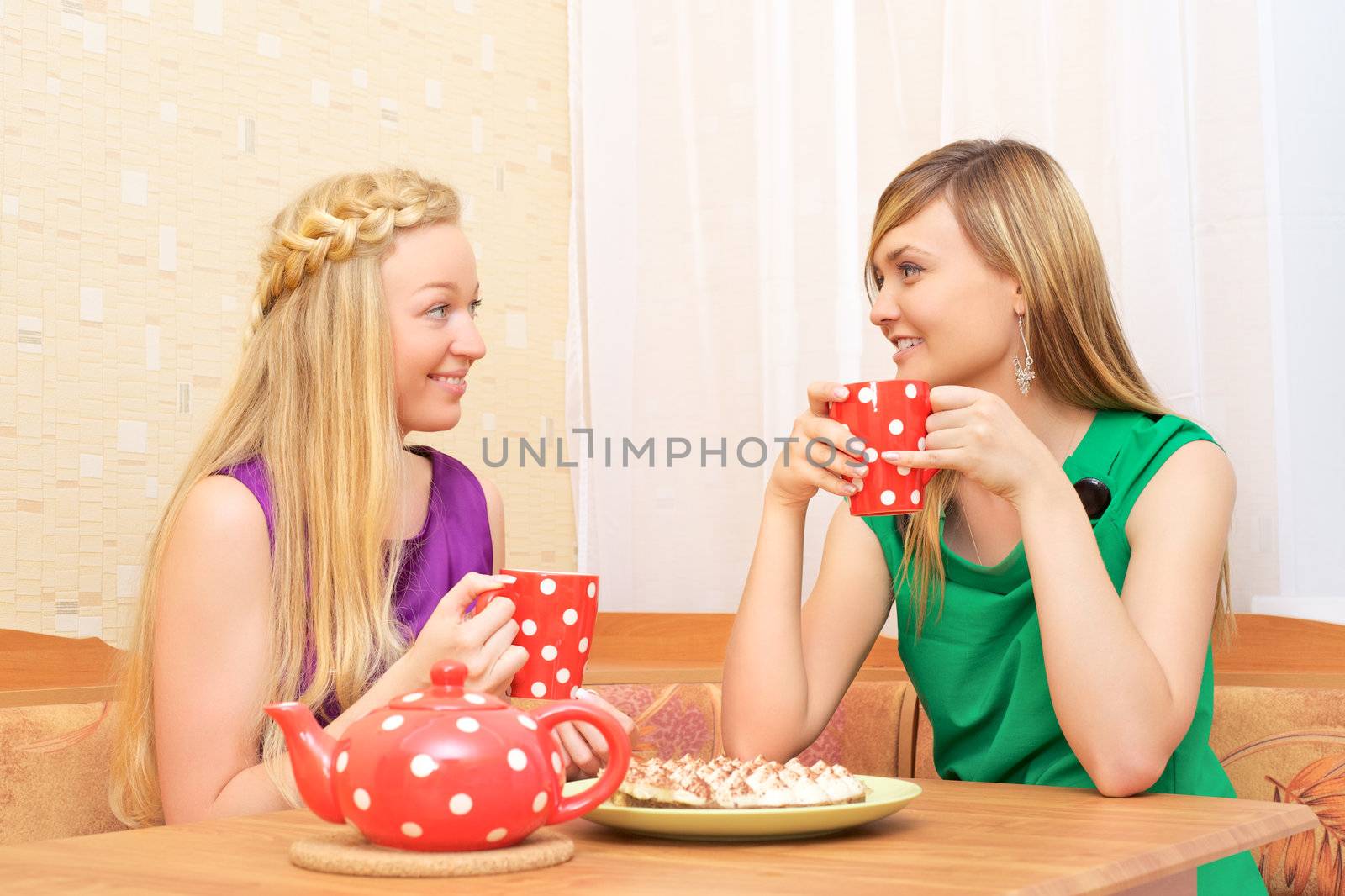 two young woman sitting at a table having tea