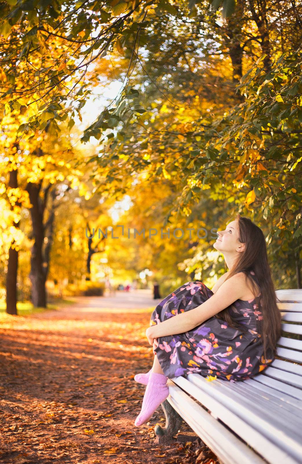 beautiful girl sitting on bench in autumn park