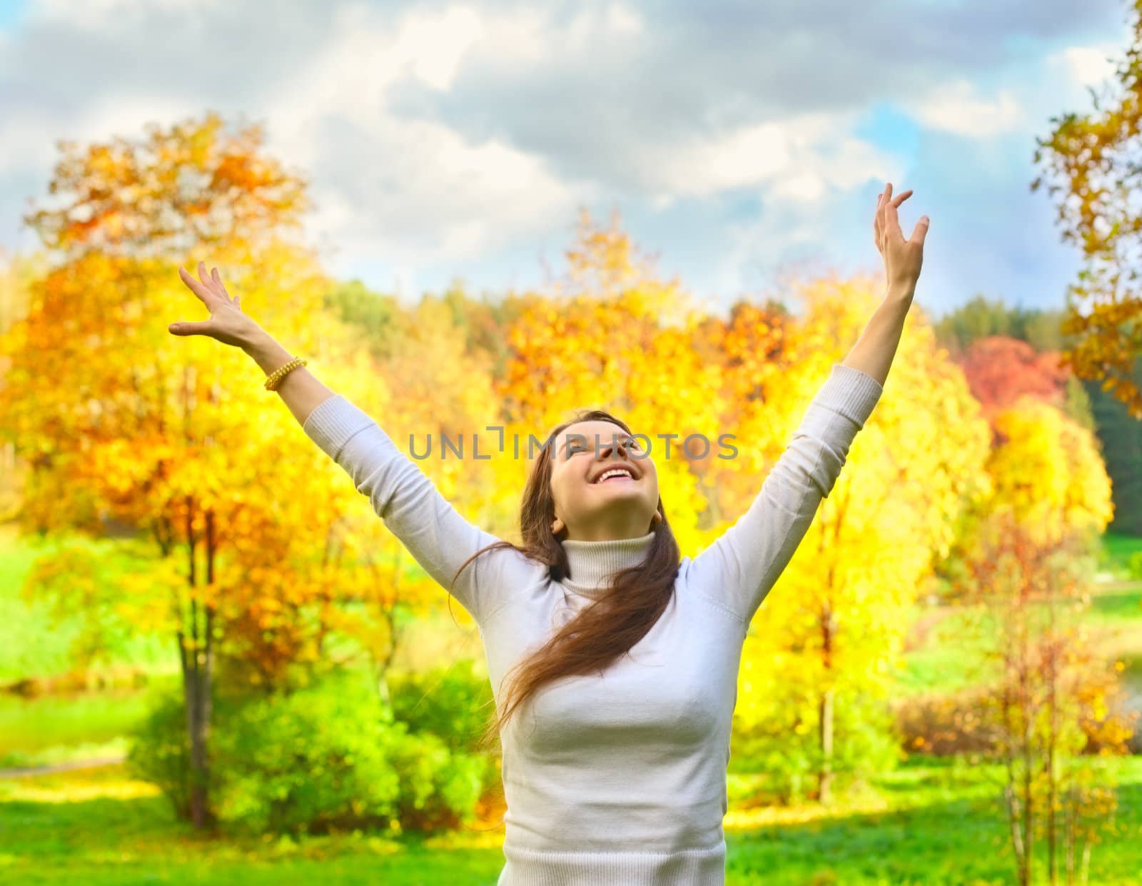 beautiful girl drop hands up in the air in autumn park