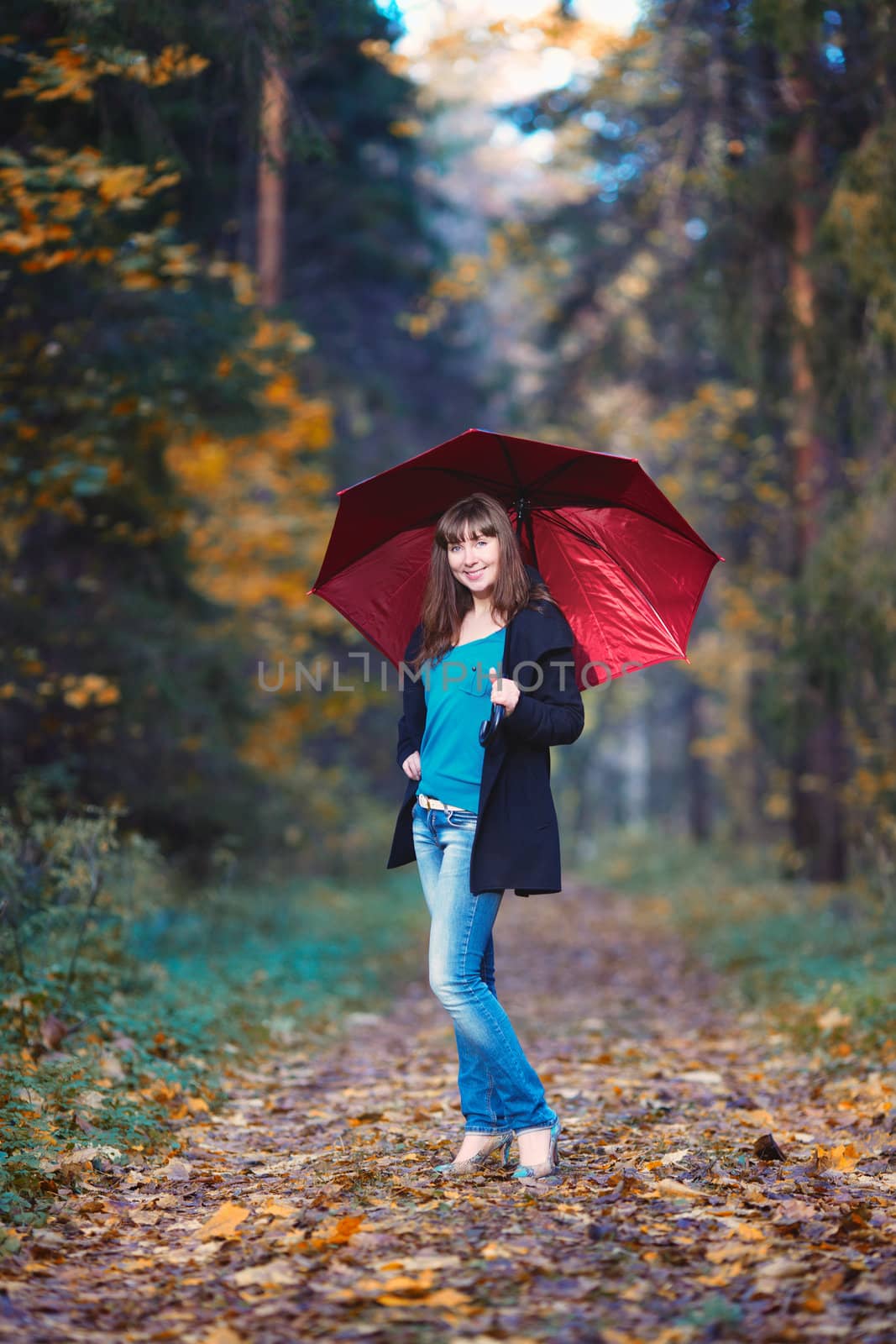 beautiful girl with red umbrella standing in autumn park