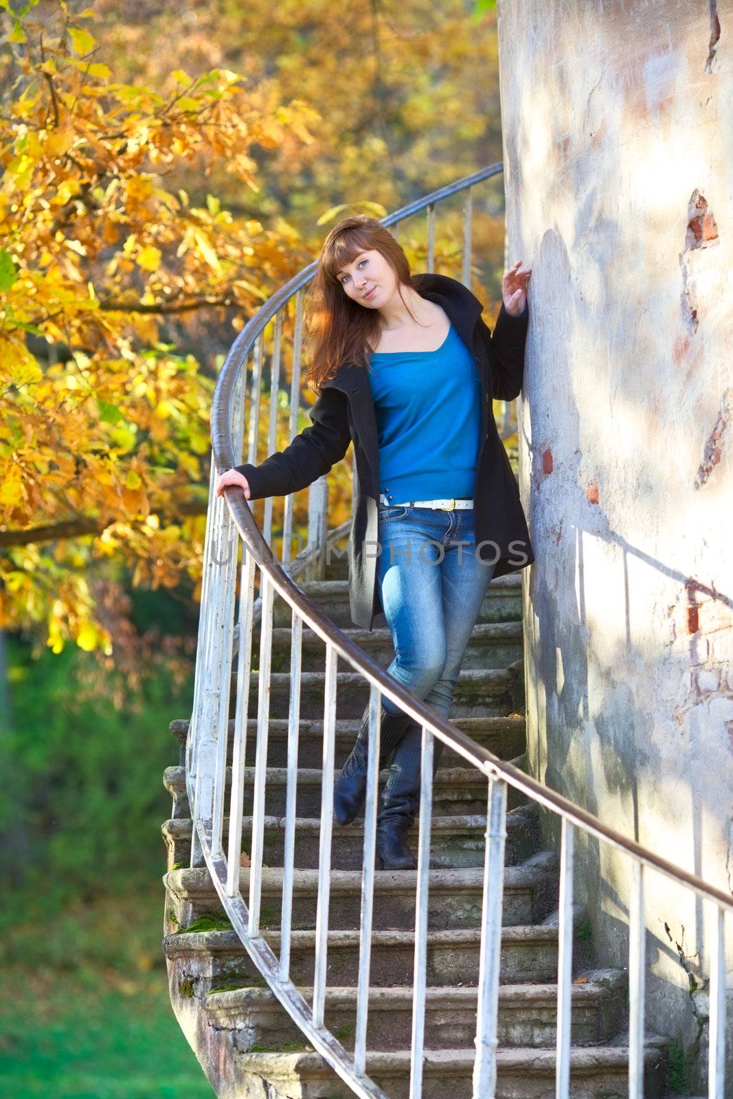 beautiful girl on tower stairway in autumn park