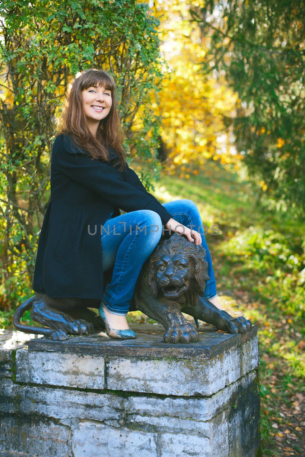 beautiful girl saddle lion sculpture at autumn park