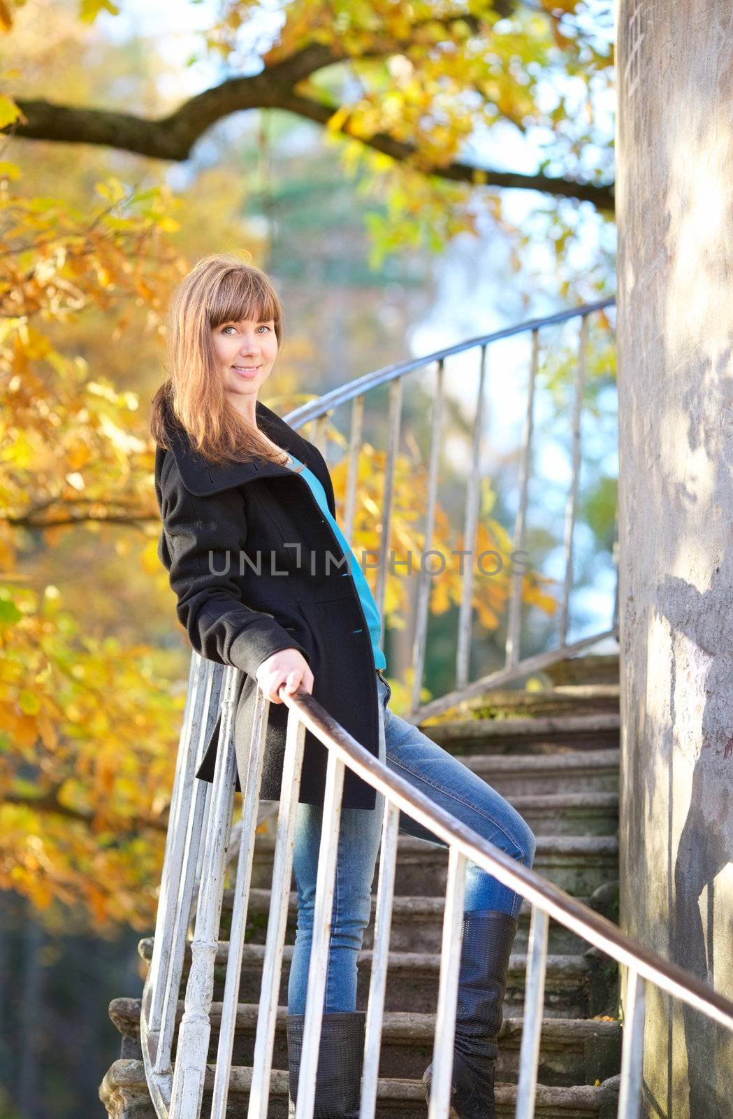 beautiful girl on tower stairway in autumn park