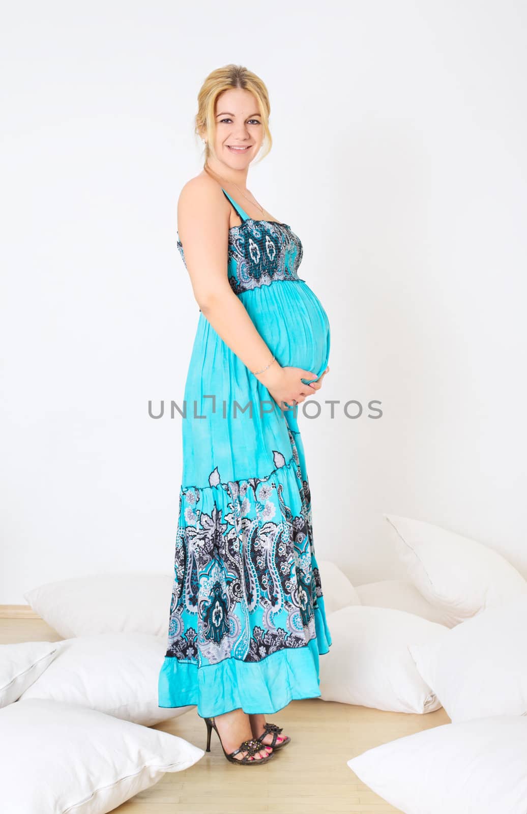 standing smiling pregnant woman in blue dress