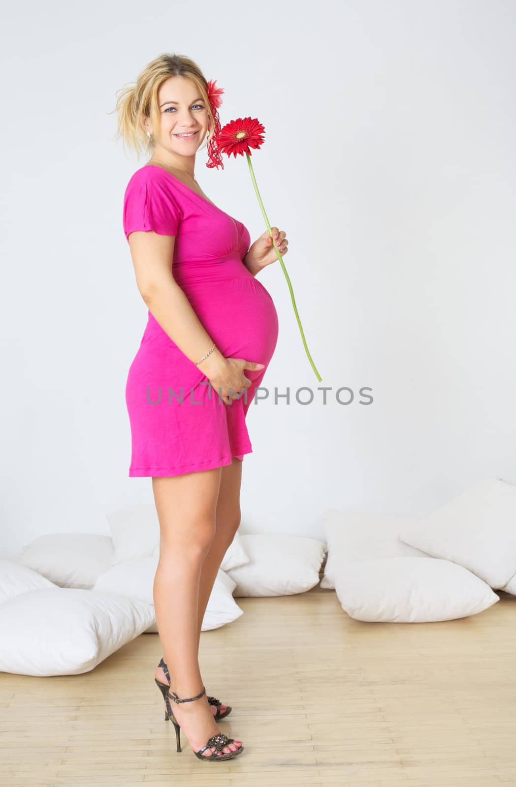 pregnant woman standing in room with gerbera