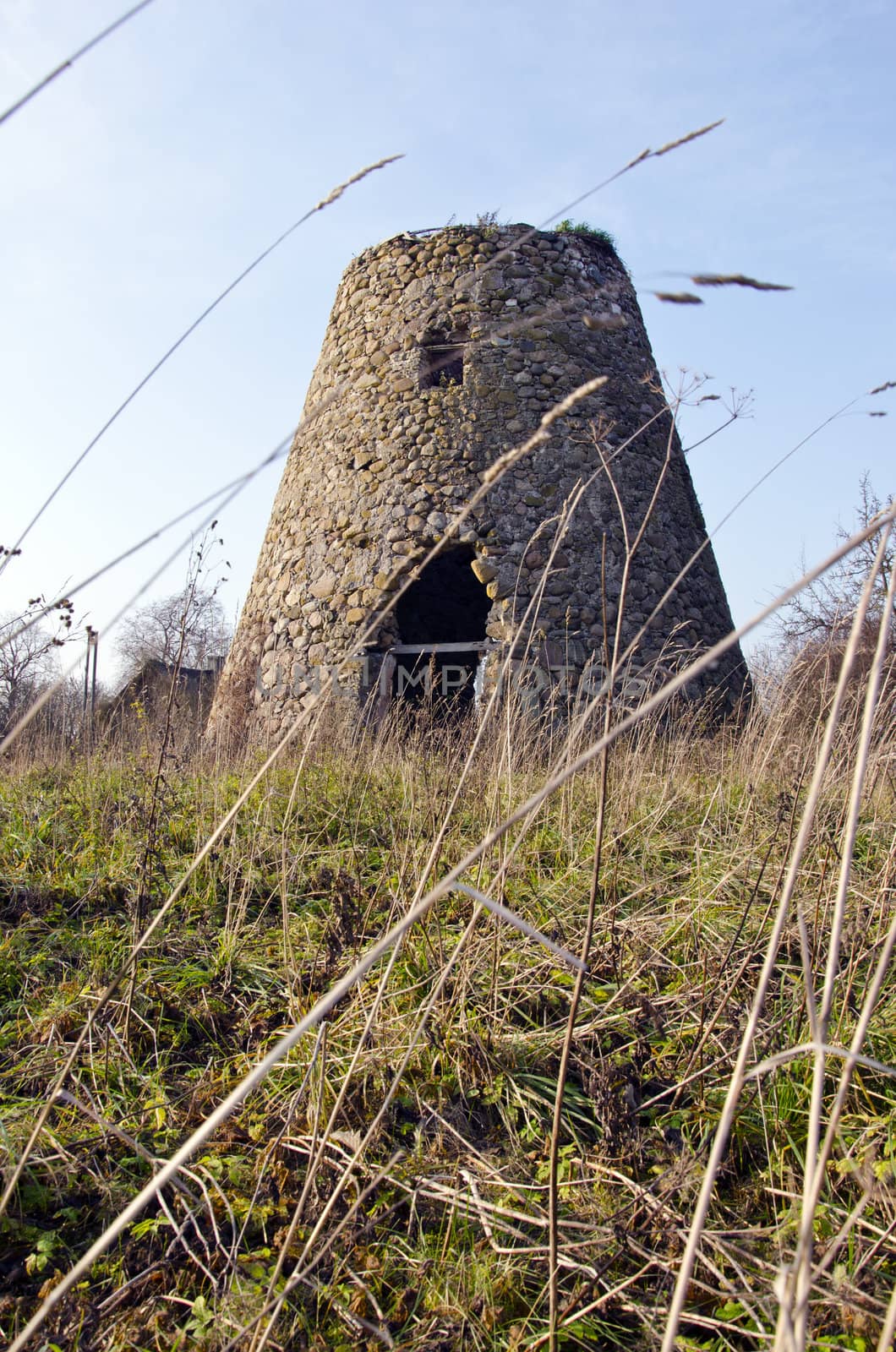 Ancient abandoned windmill built of stones fragment. Retro vintage architecture nostalgia.