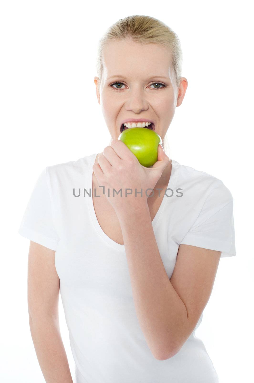 Healthy young girl eating nutritious green apple by stockyimages