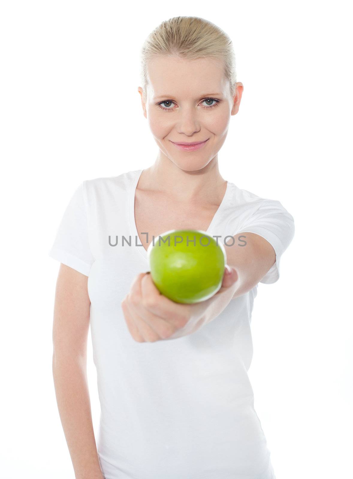 Cute teenager offering green apple dressed in white top