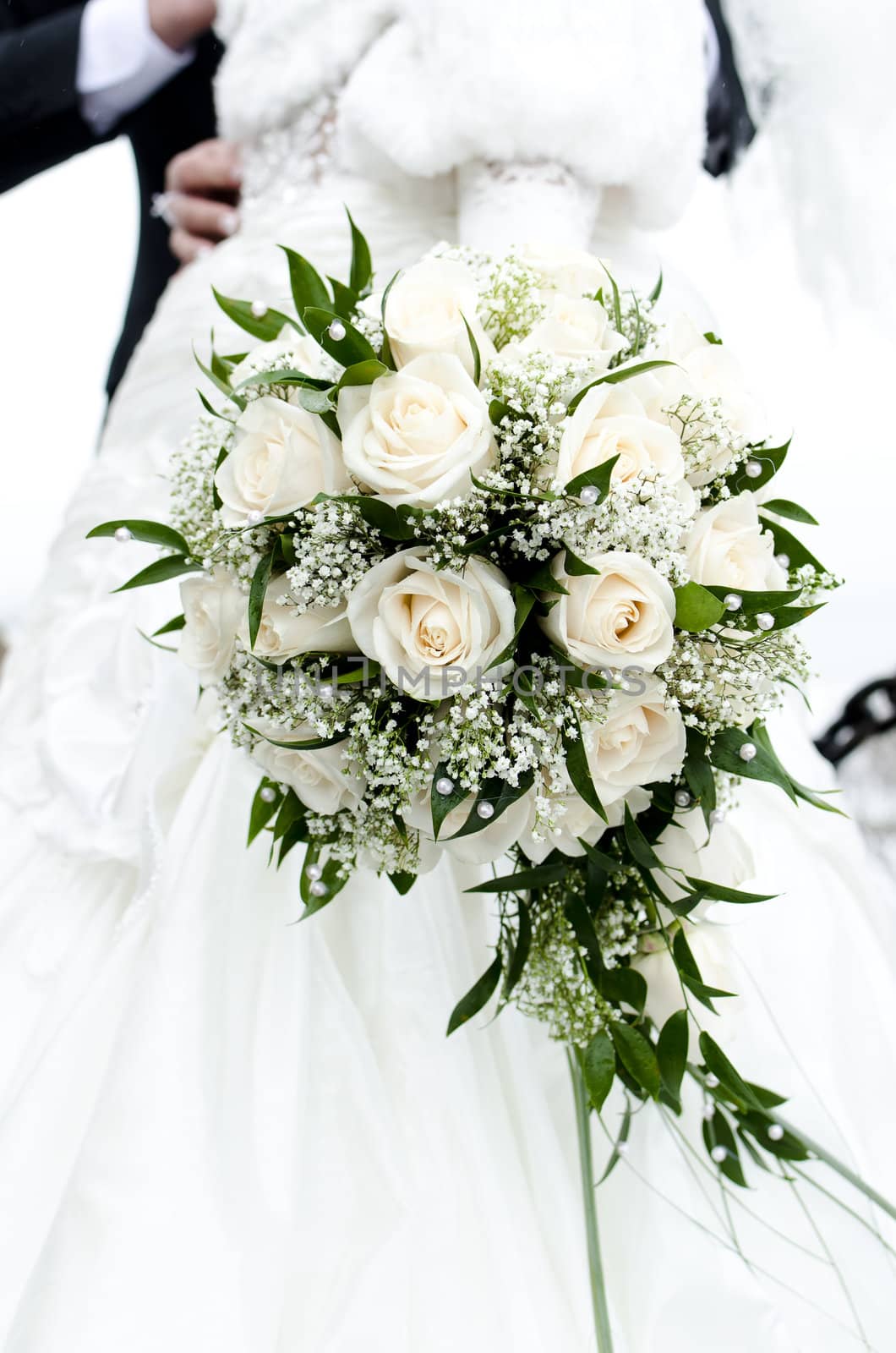 Bridal bouquet of flowers in the hands of newlyweds