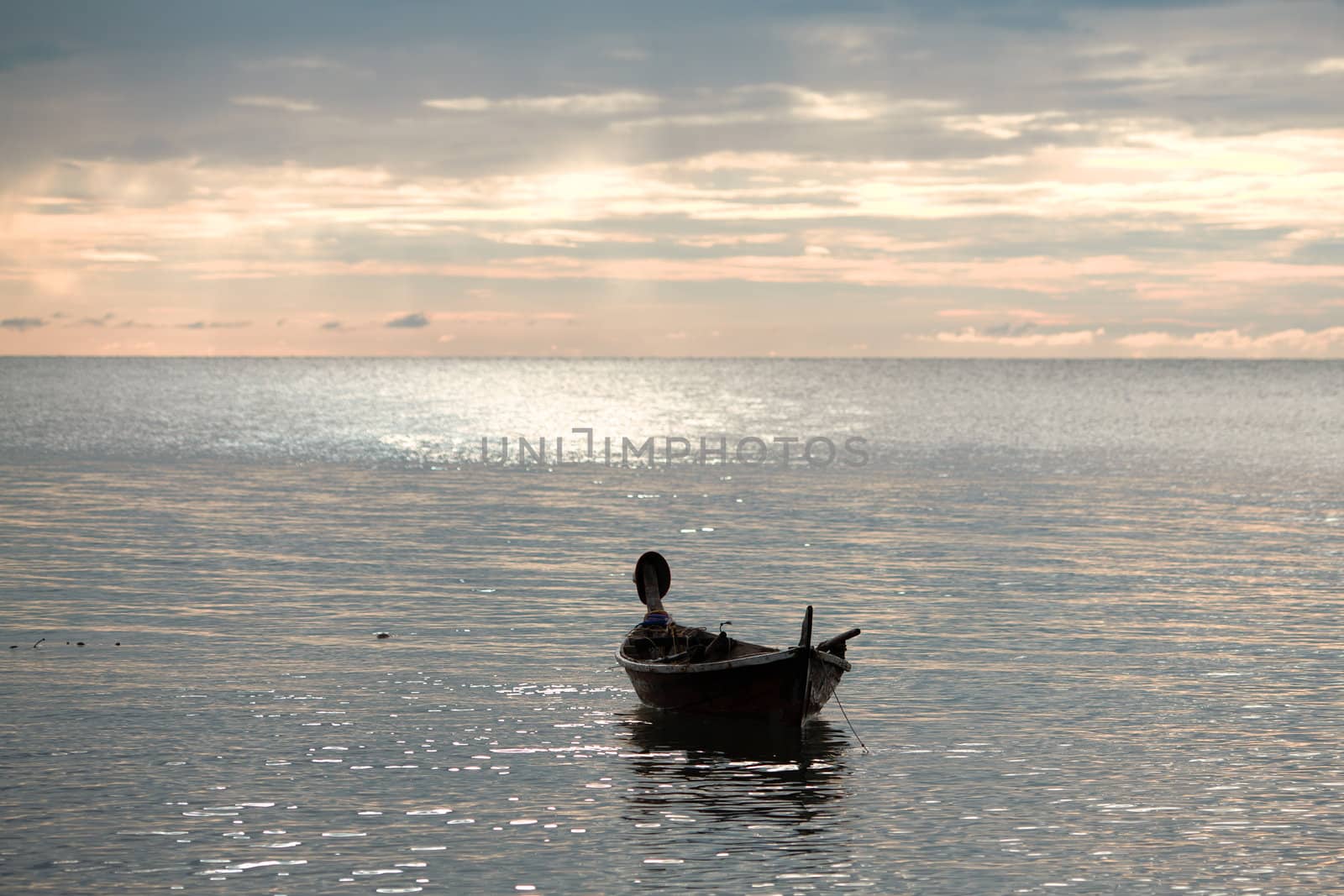 abandoned boat on waves under sunset, Andaman Sea, Thailand