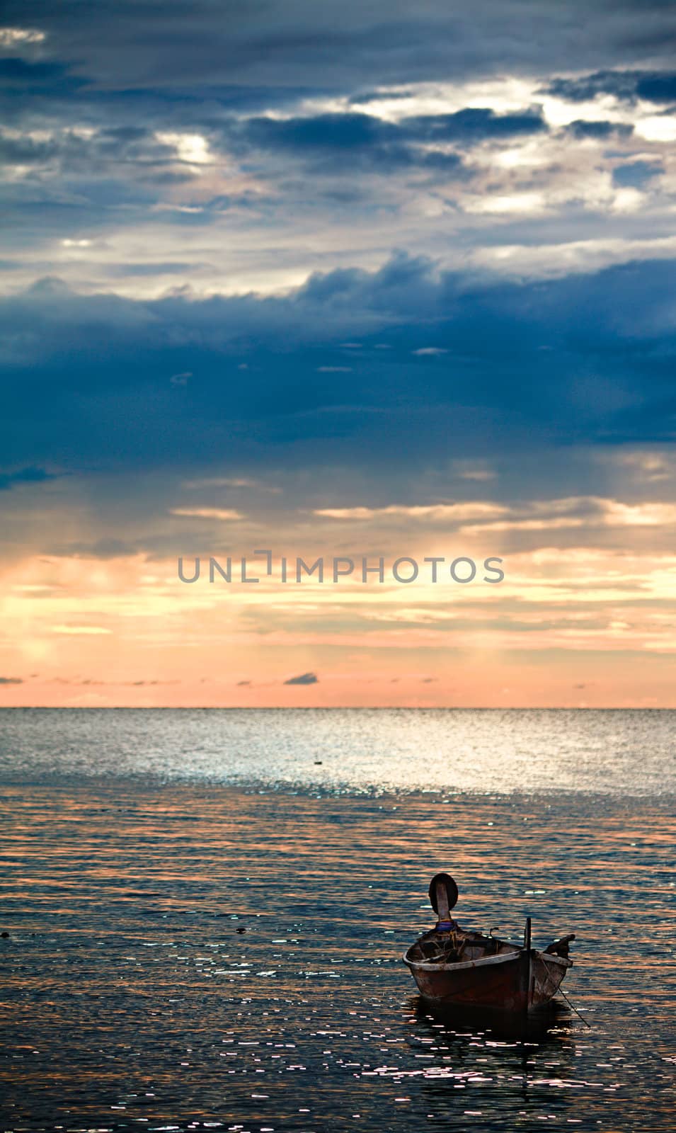 abandoned boat on waves under sunset, Andaman Sea, Thailand