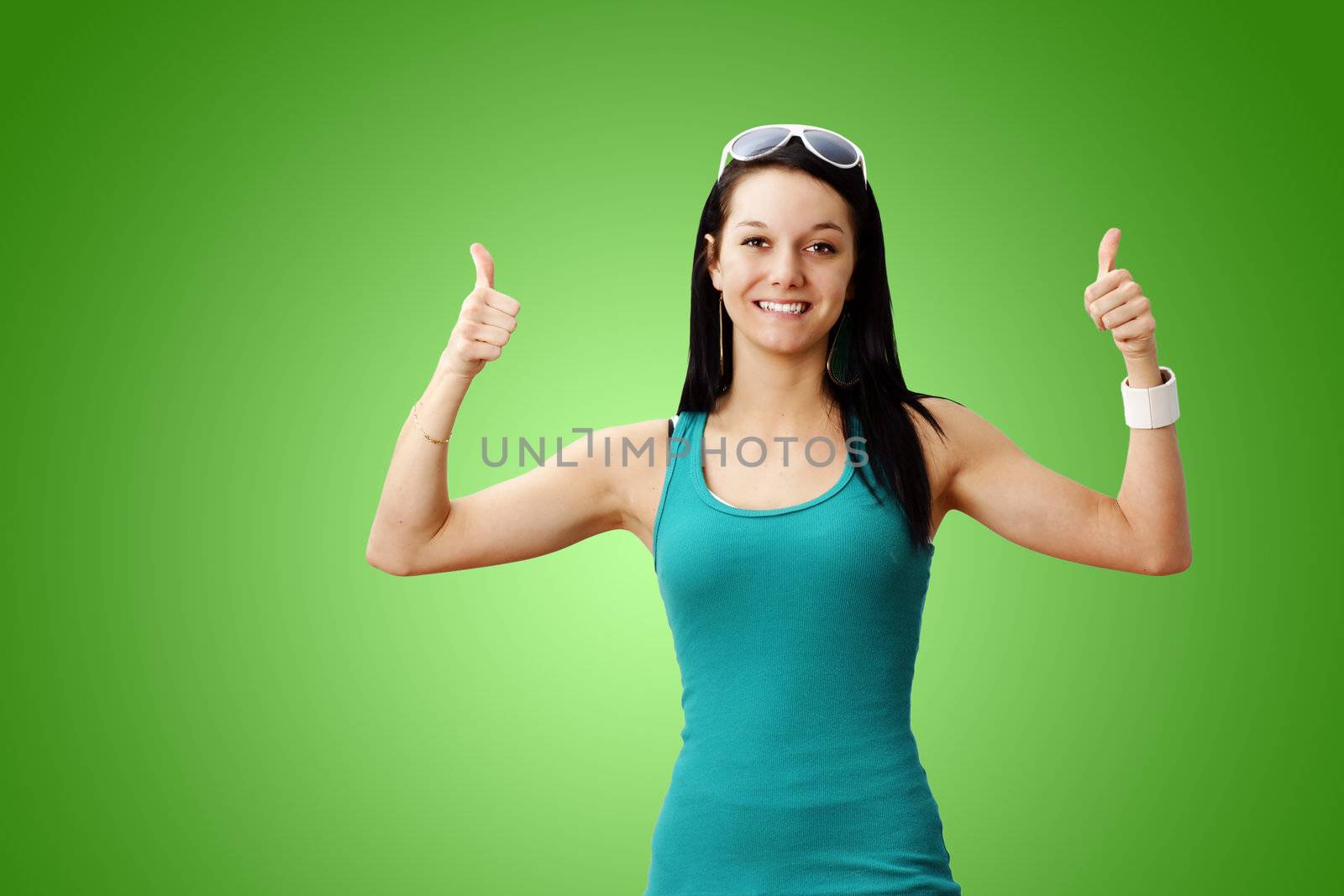 Pretty healthy and lean young woman smiling giving two thumbs up over gradient green background: perfect for weight loss or other achievement.