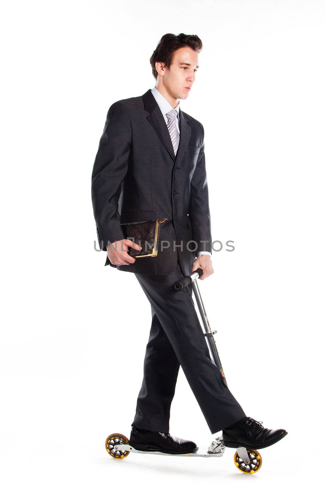 Portrait of a young respectable and successful man in a dark business suit who rides a scooter