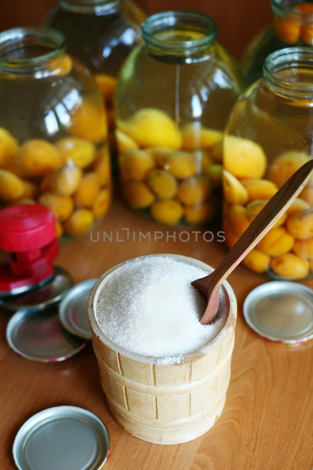 An image of sugar and jars with apricots