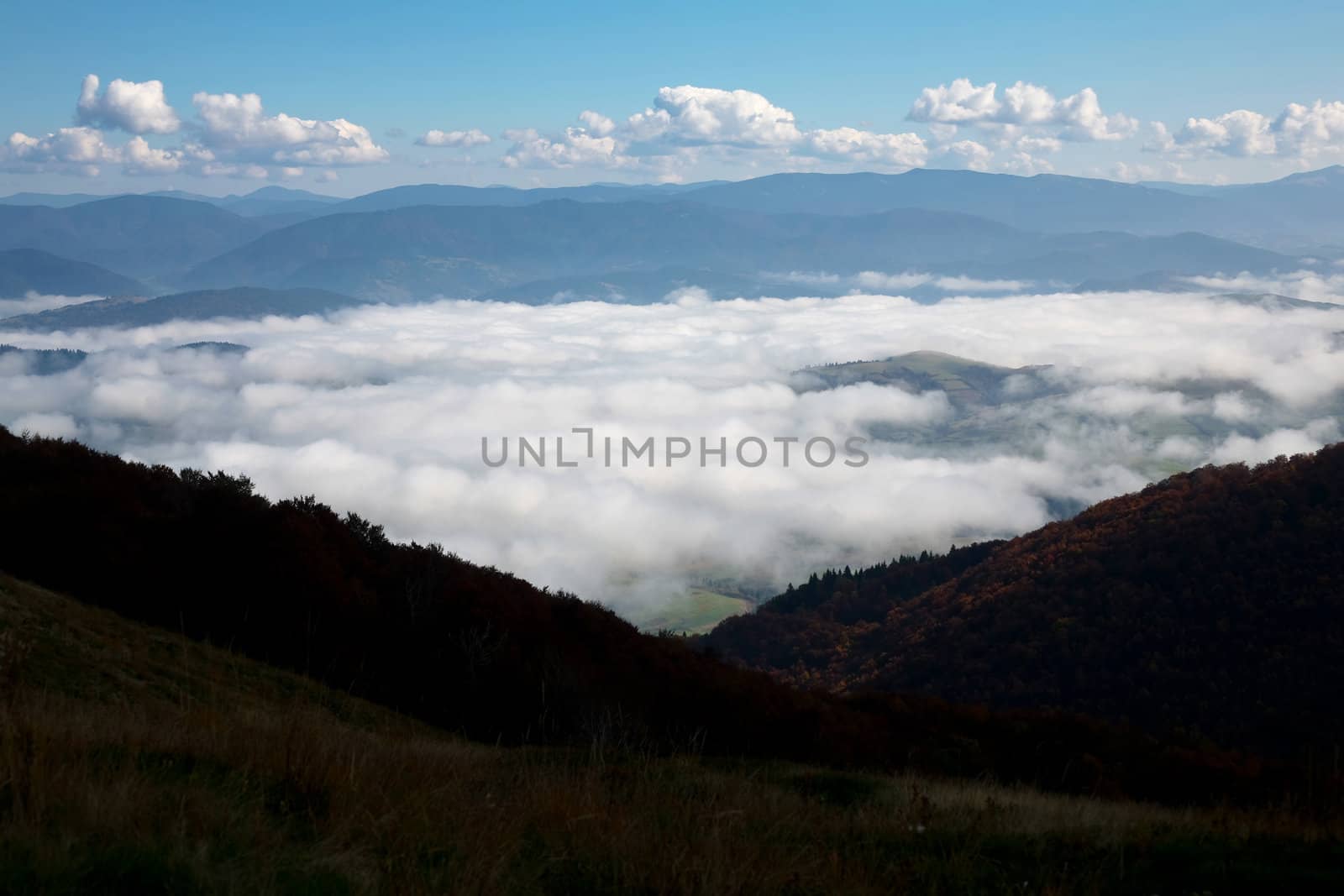 An image of white clouds over the mountains