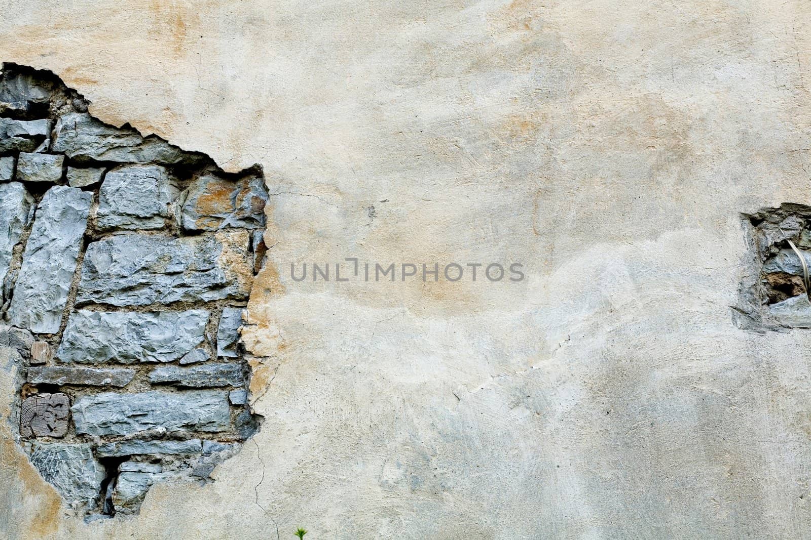 An old grey wall with plaster partially off