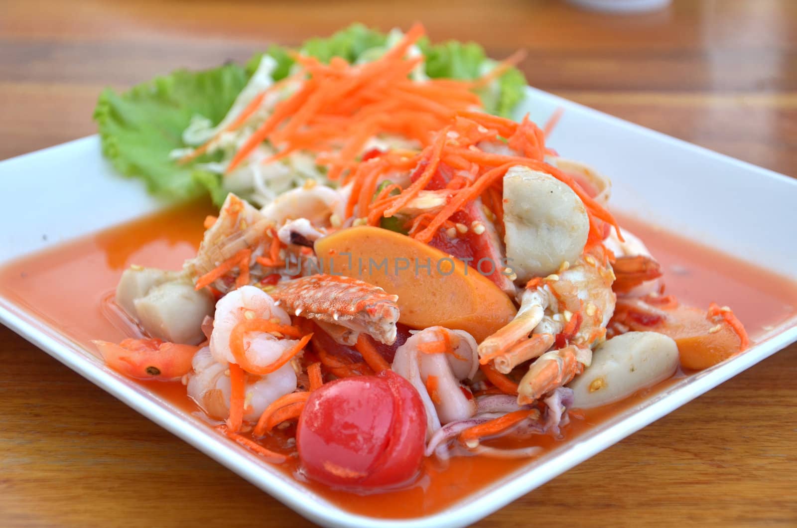 Thai cuisine ,  spicy seafood salad on wooden table