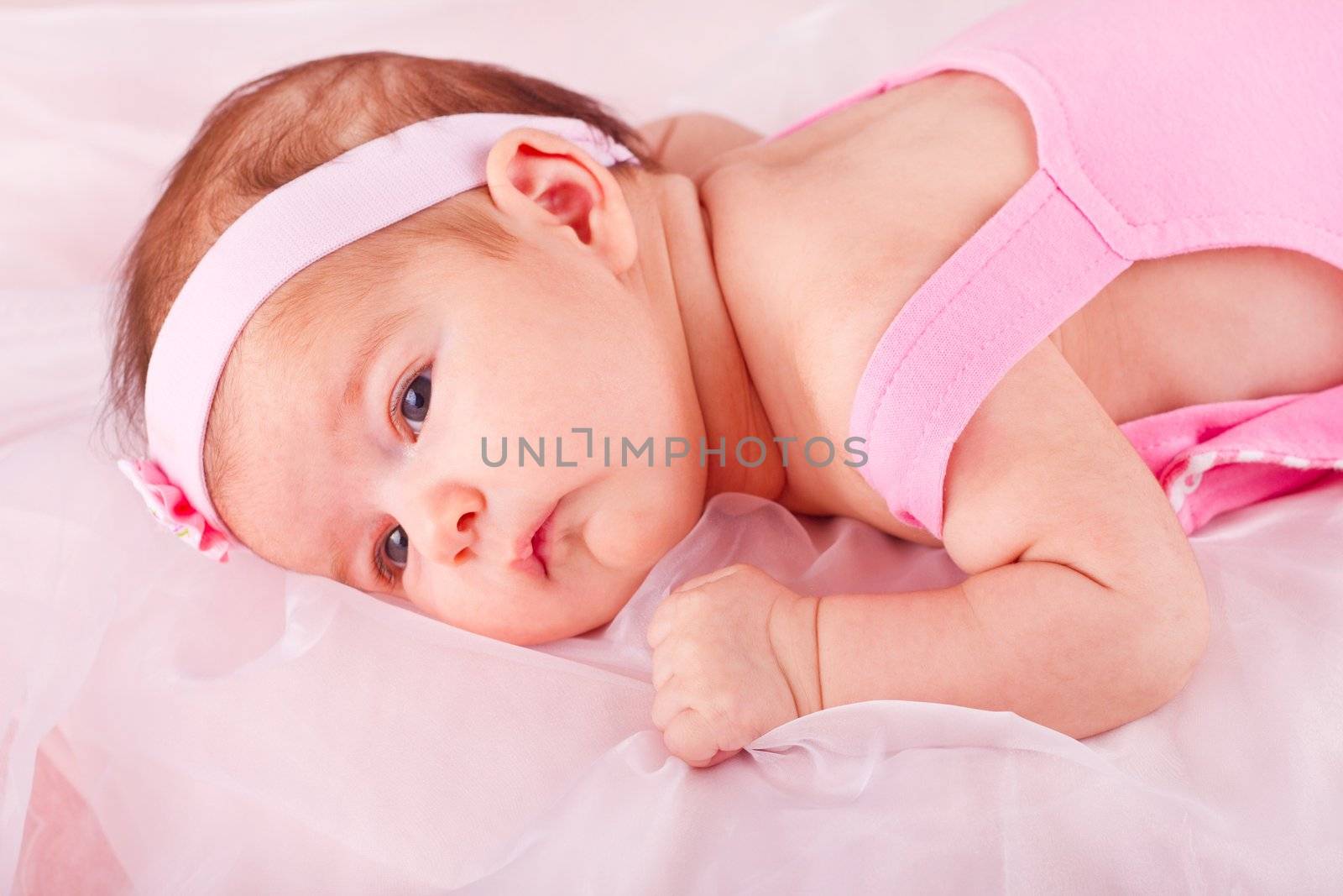 View of a newborn baby on smooth bed.