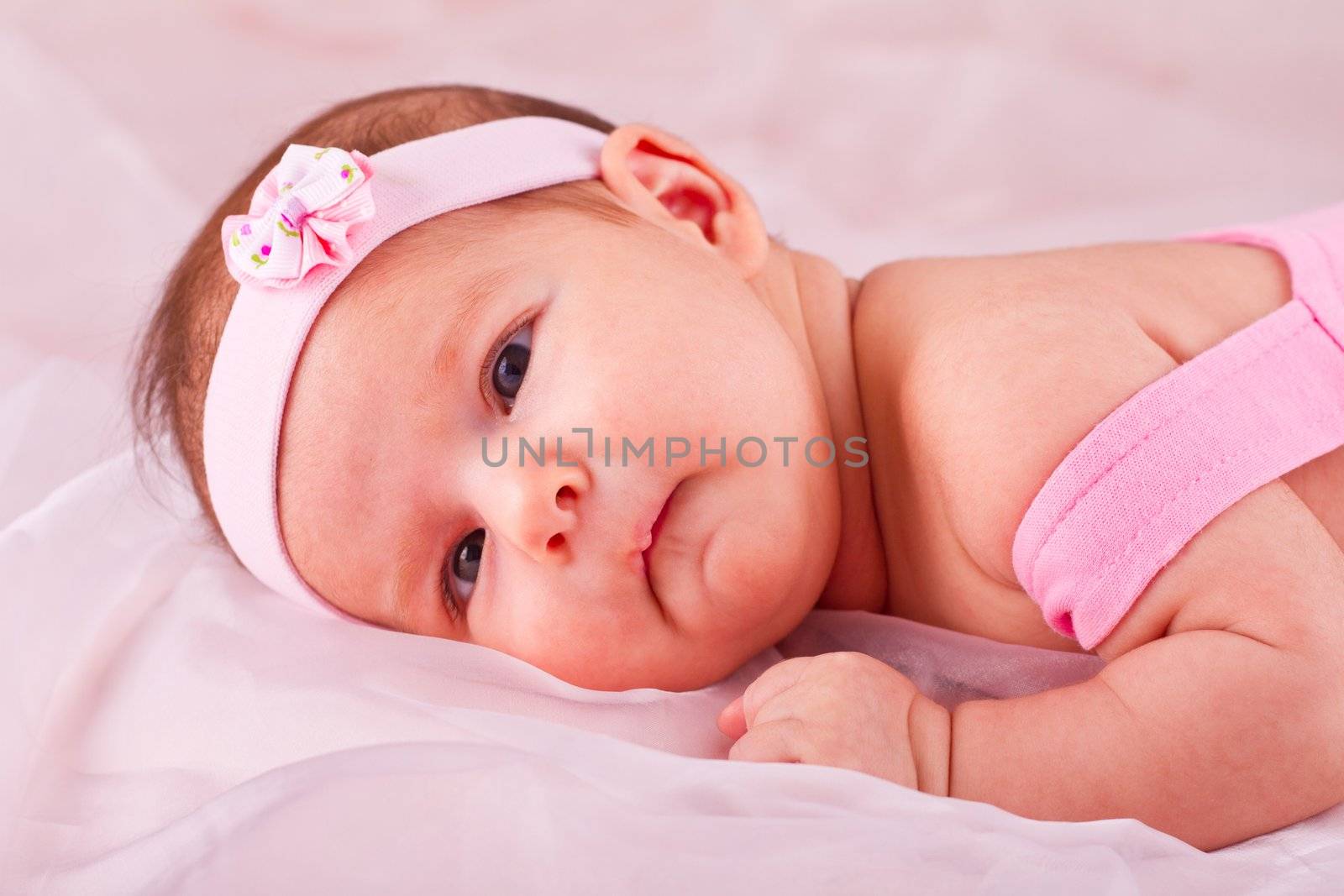 View of a newborn baby on smooth bed.