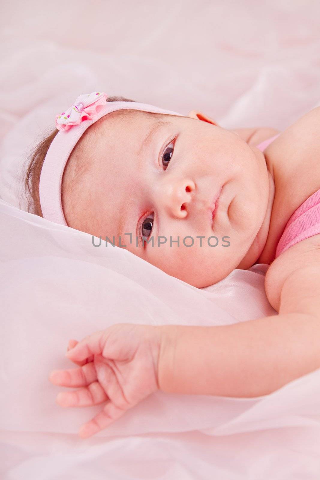 View of a newborn baby on smooth bed.