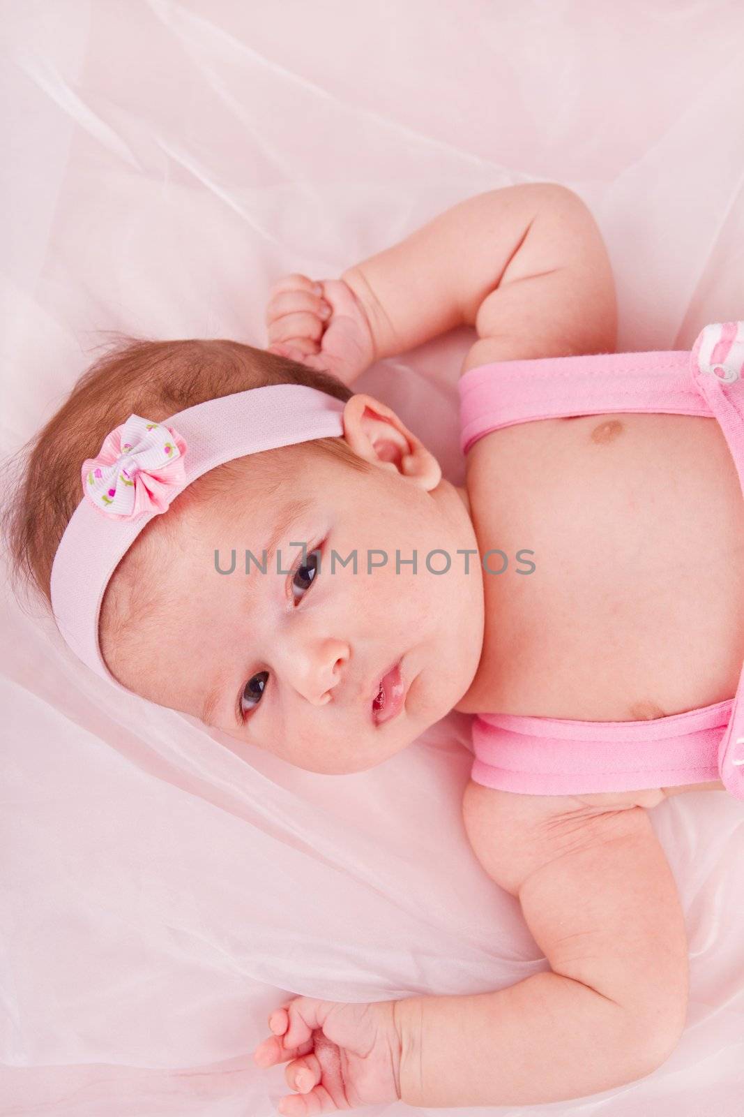View of a newborn baby on smooth bed.