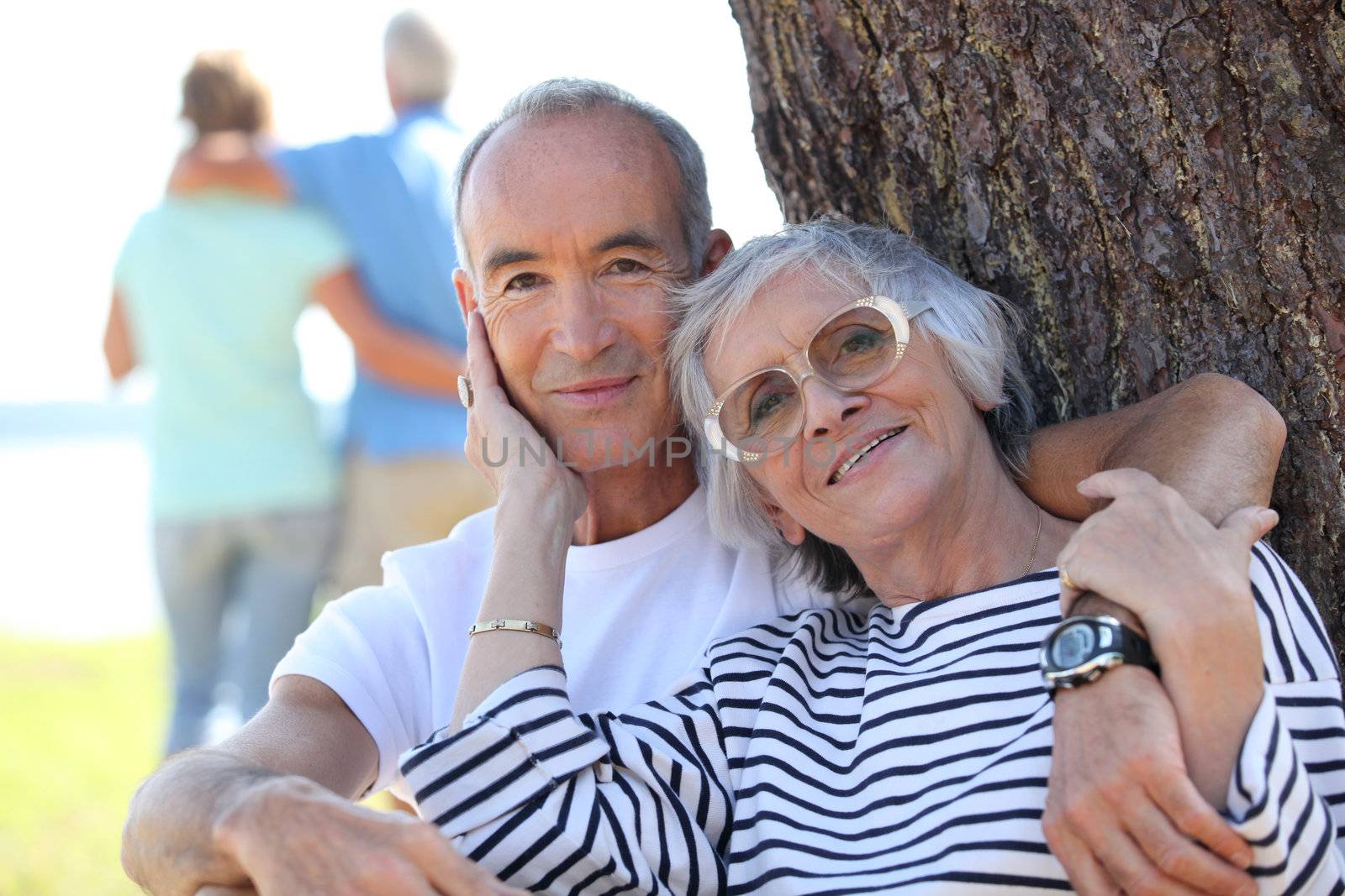 Senior couple embracing in a field by phovoir